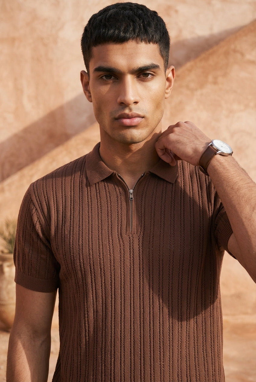 Man wearing a brown ribbed knit shirt against a desert background