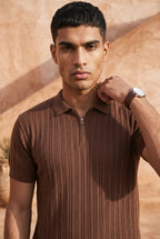 Man wearing a brown ribbed knit shirt against a desert background