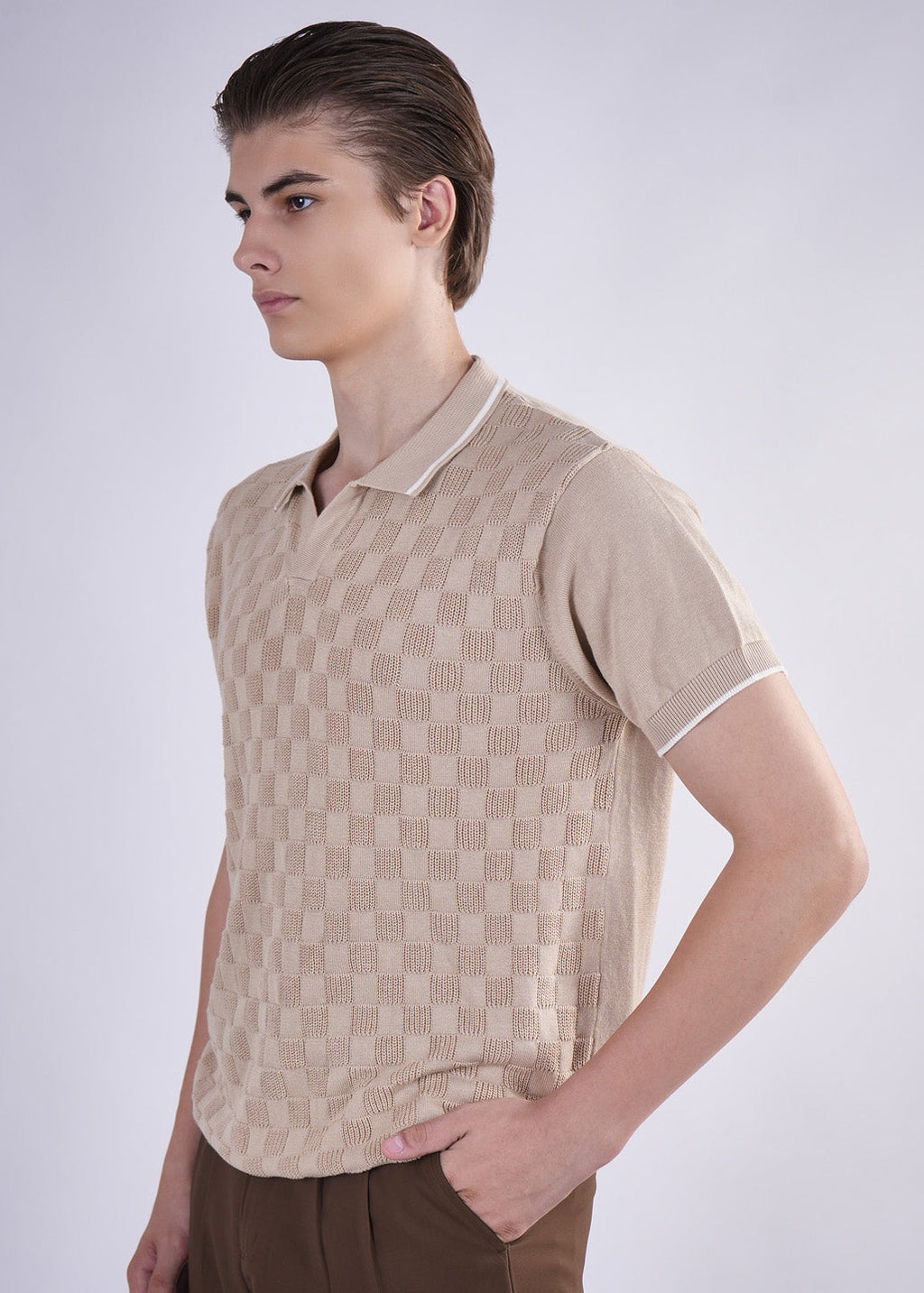 Man wearing a beige patterned polo shirt on a white background