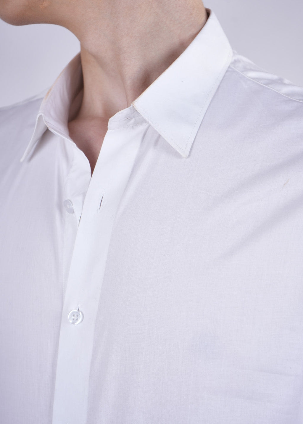 Close-up of a white shirt with a collar and button details.