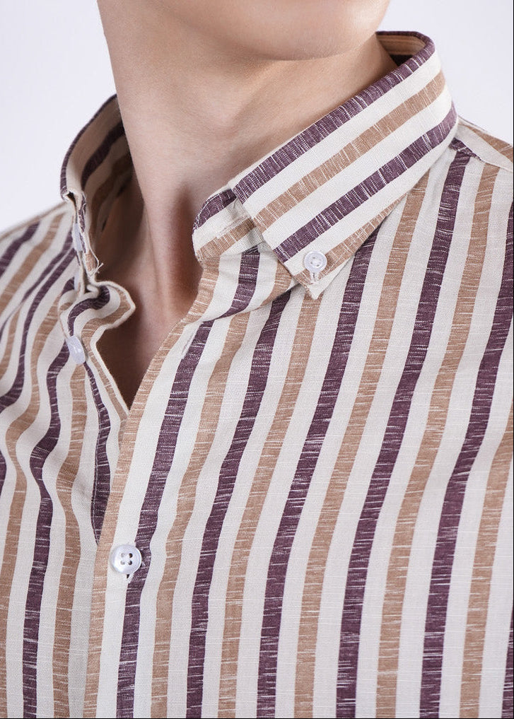 Close-up of a person wearing a striped shirt with a plain background