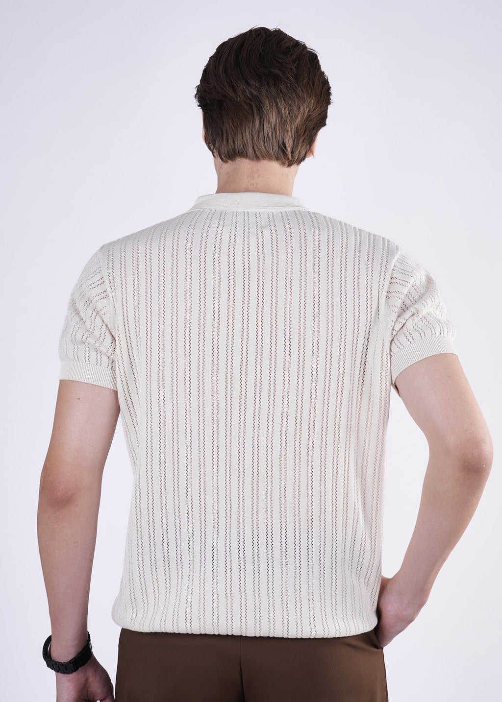 Man wearing a white textured shirt on a plain background