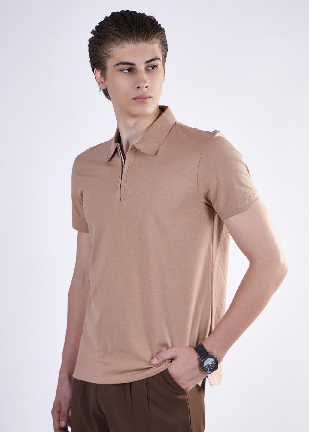 Man wearing a brown polo shirt and pants on a white background