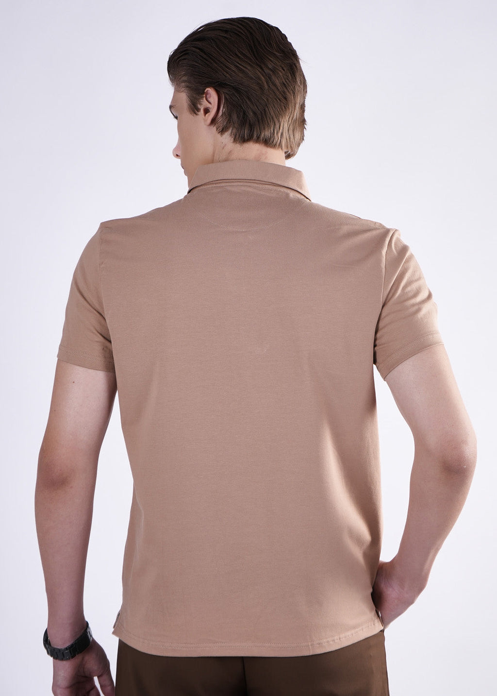 Man wearing a beige polo shirt on a white background
