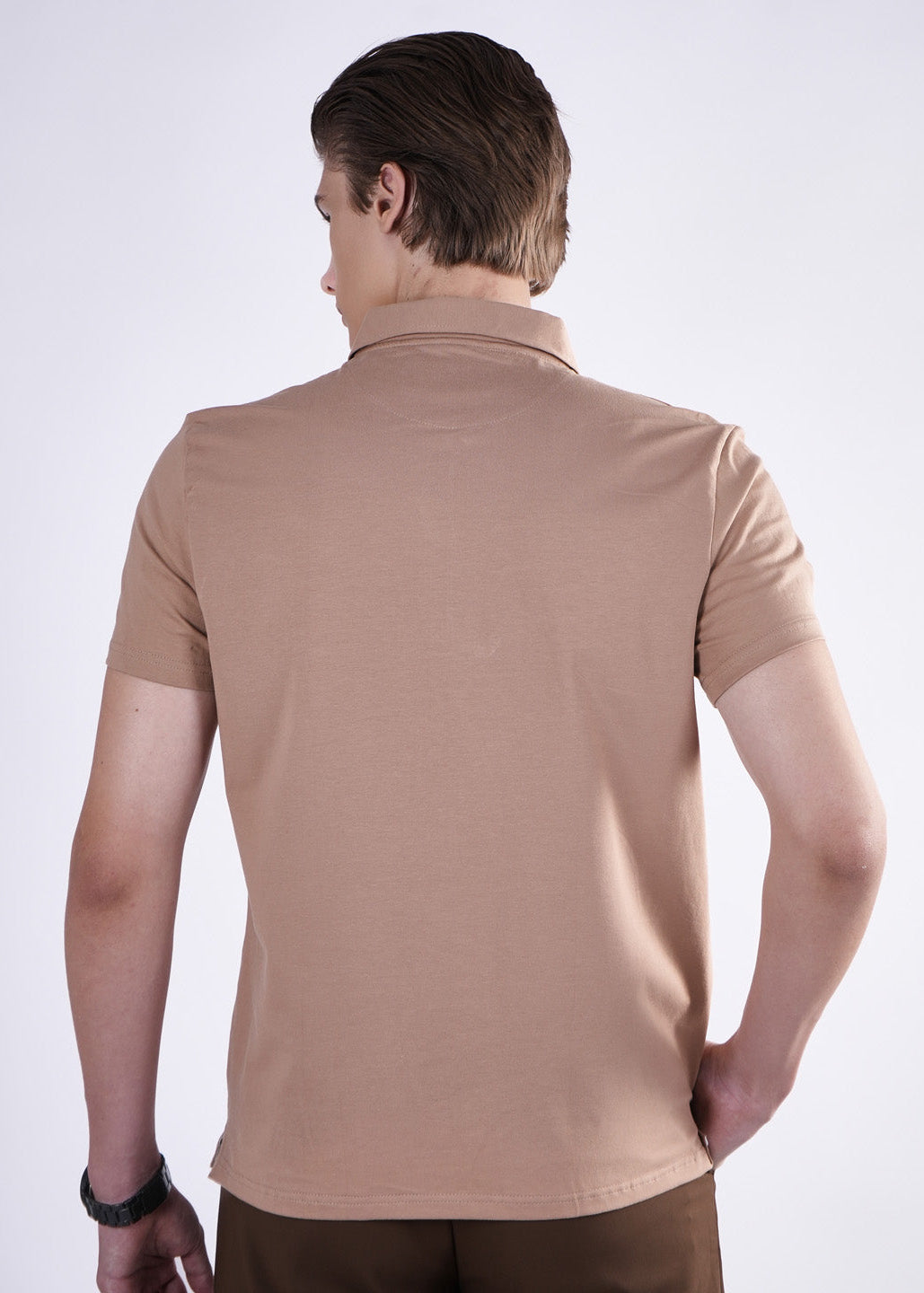Man wearing a beige polo shirt on a white background