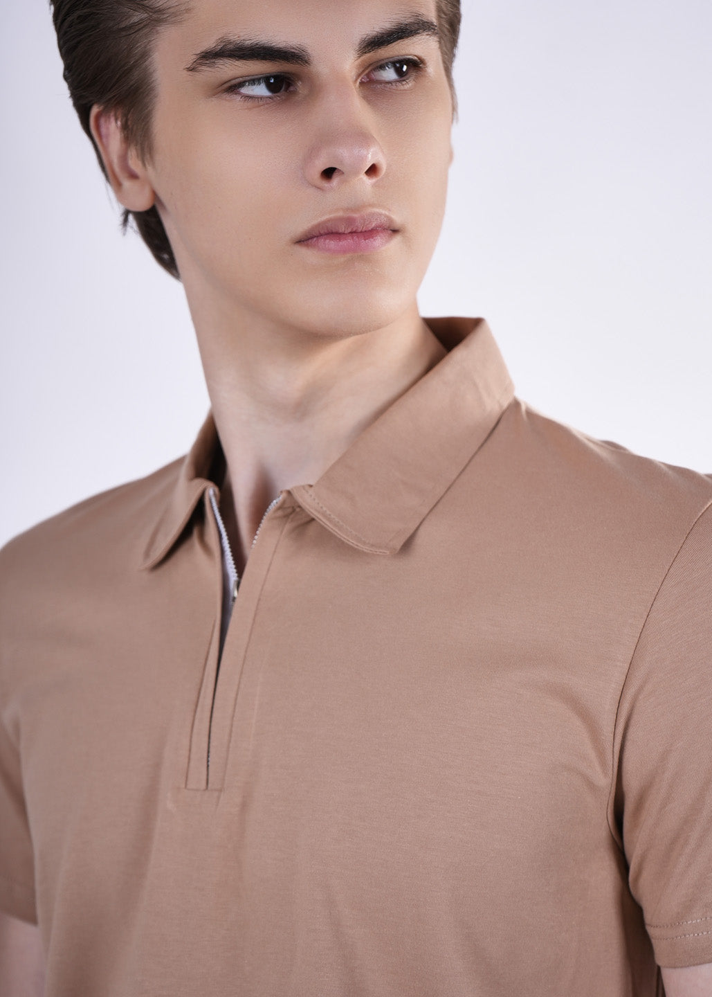 Man wearing a brown polo shirt against a white background