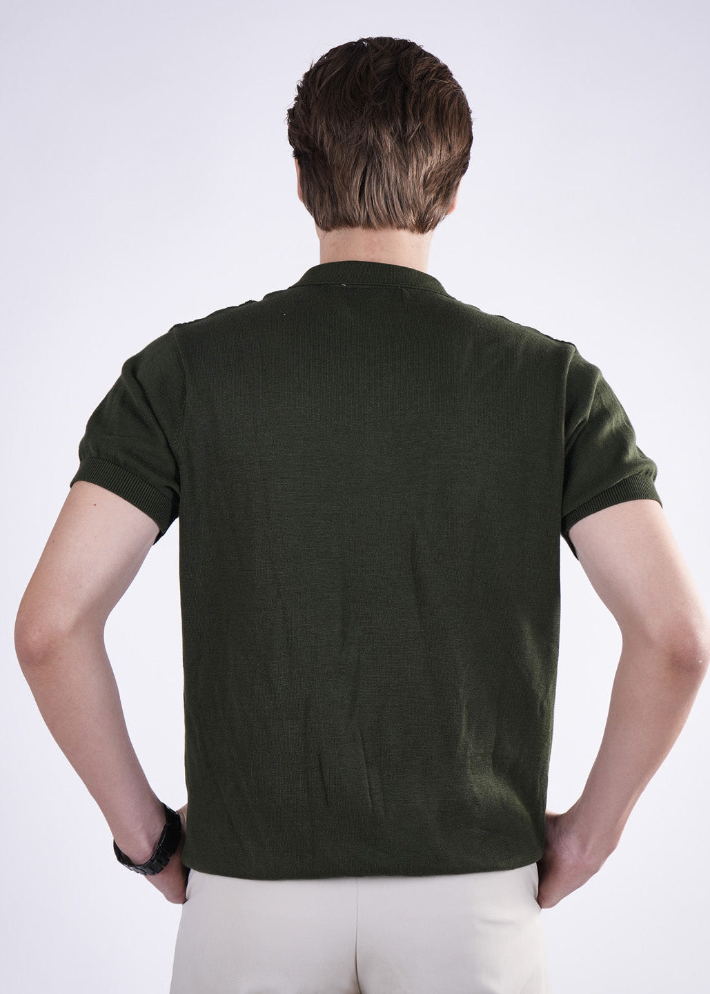 Man wearing a dark green polo shirt on a white background