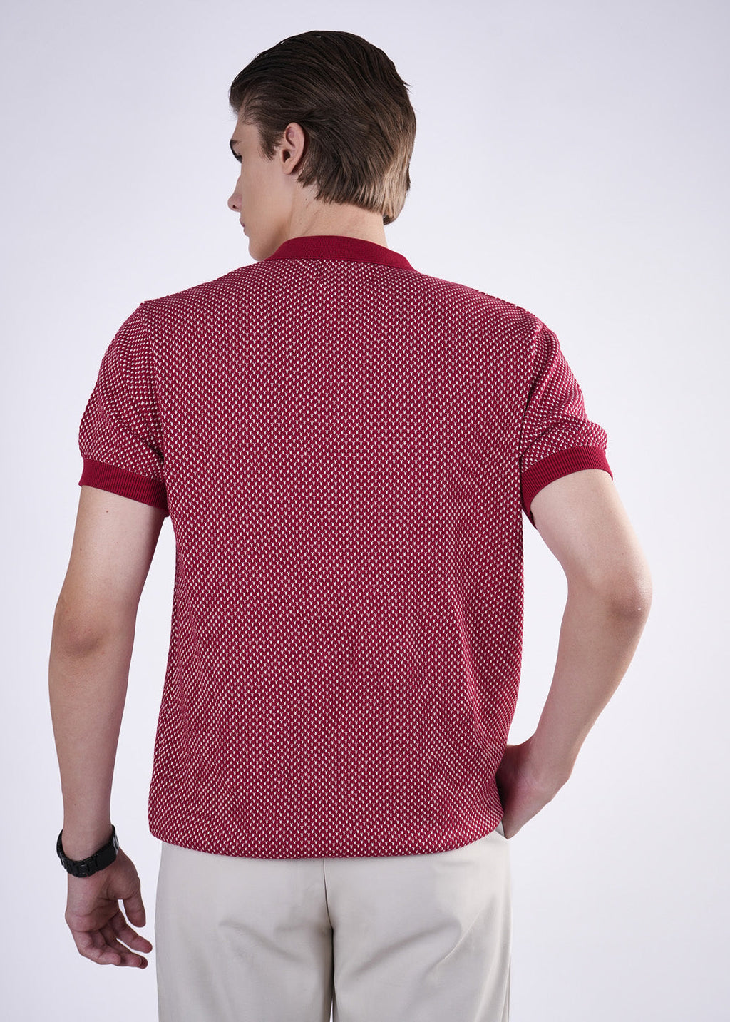 Man wearing a red patterned polo shirt on a white background
