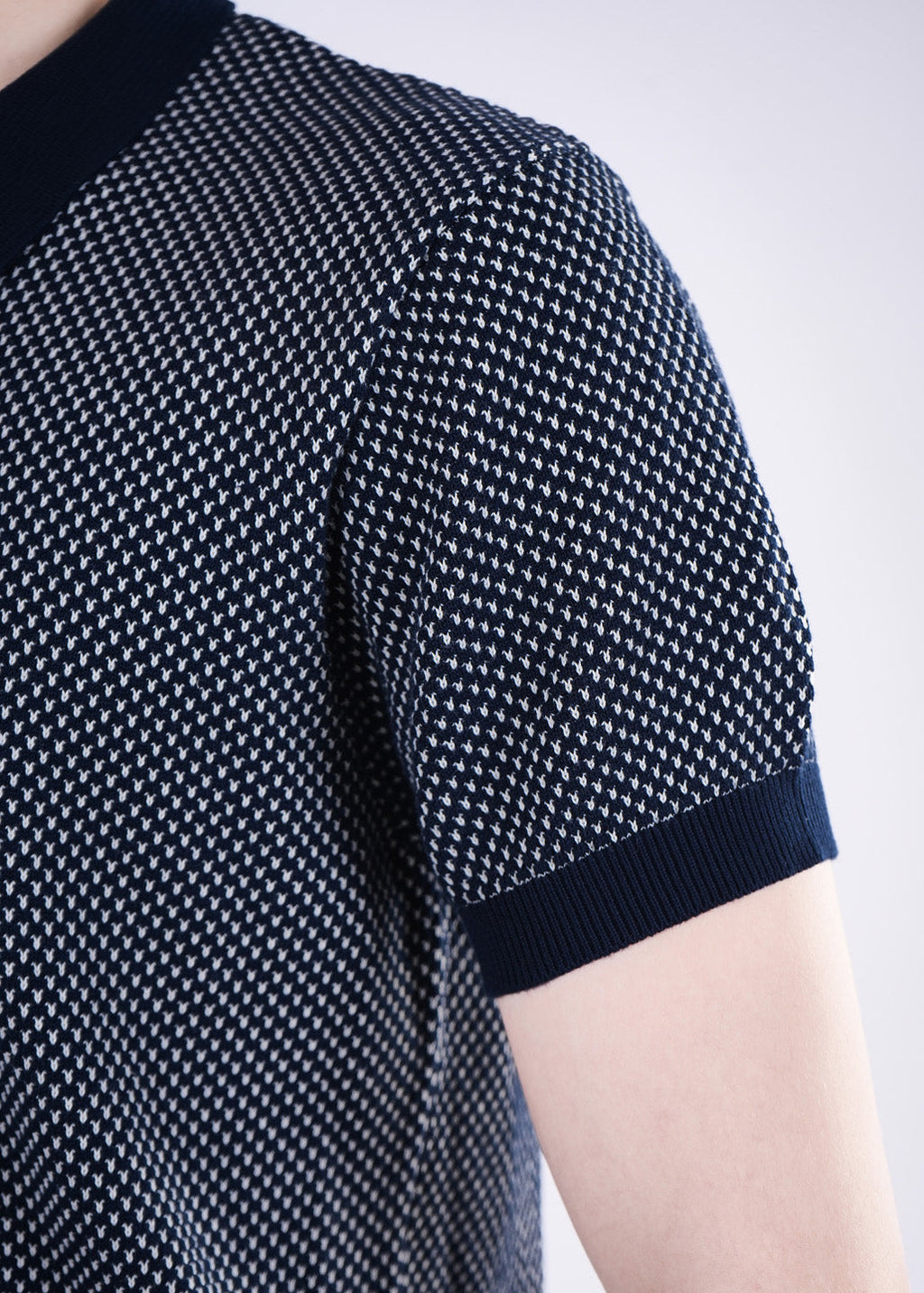Navy blue patterned shirt worn by a person on a light gray background