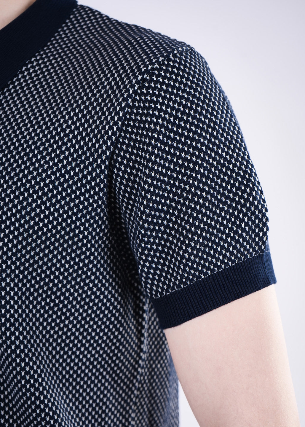 Navy blue patterned shirt worn by a person on a light gray background