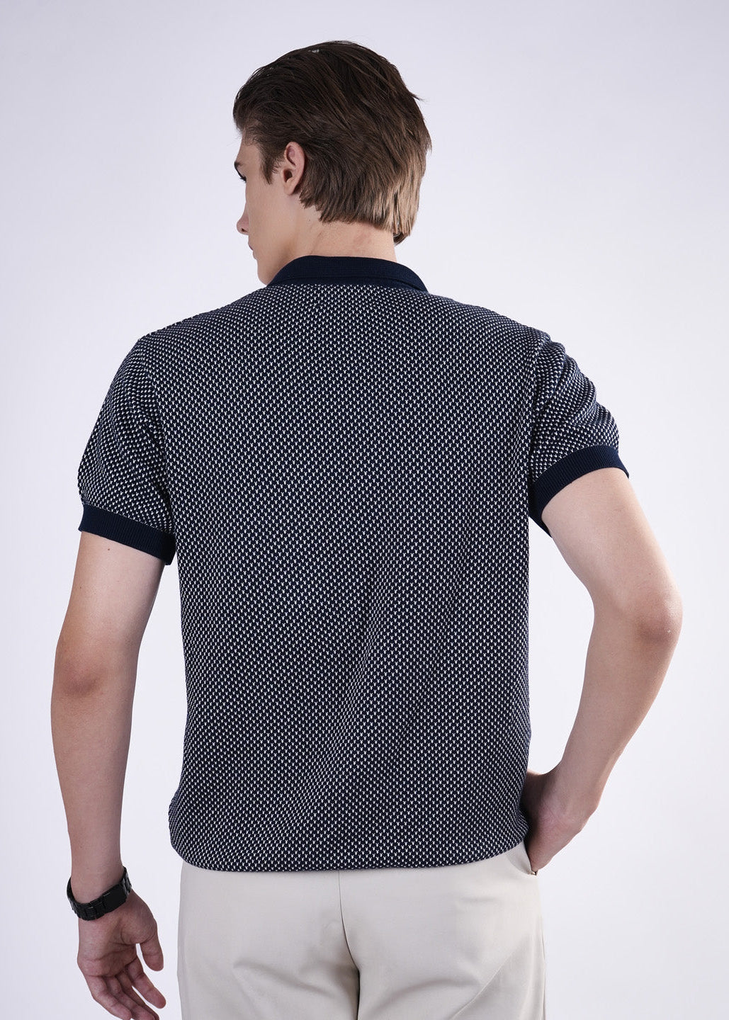 Man wearing a patterned polo shirt on a white background