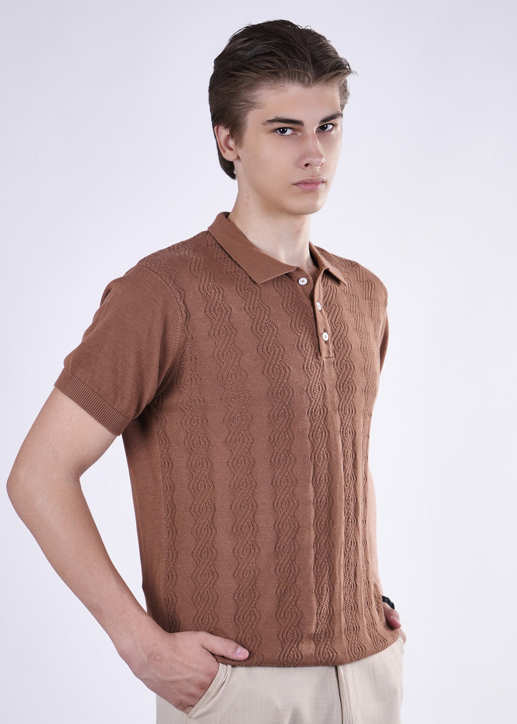 Man wearing a brown knitted polo shirt against a white background