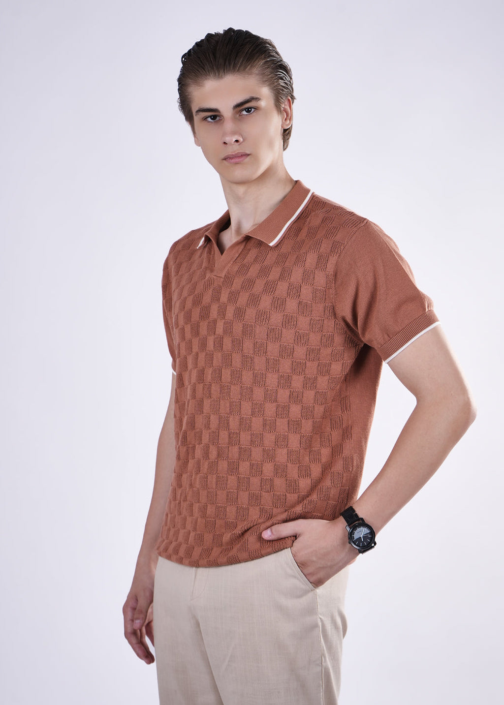 Man wearing a brown patterned polo shirt on a white background