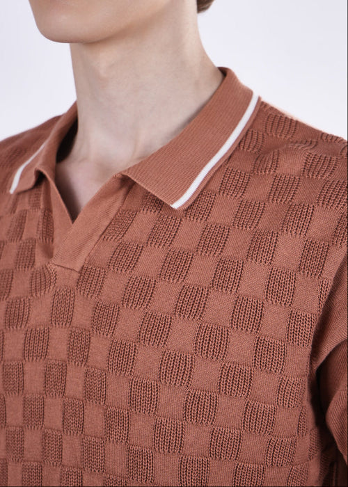 Man wearing a brown checkered polo shirt against a white background