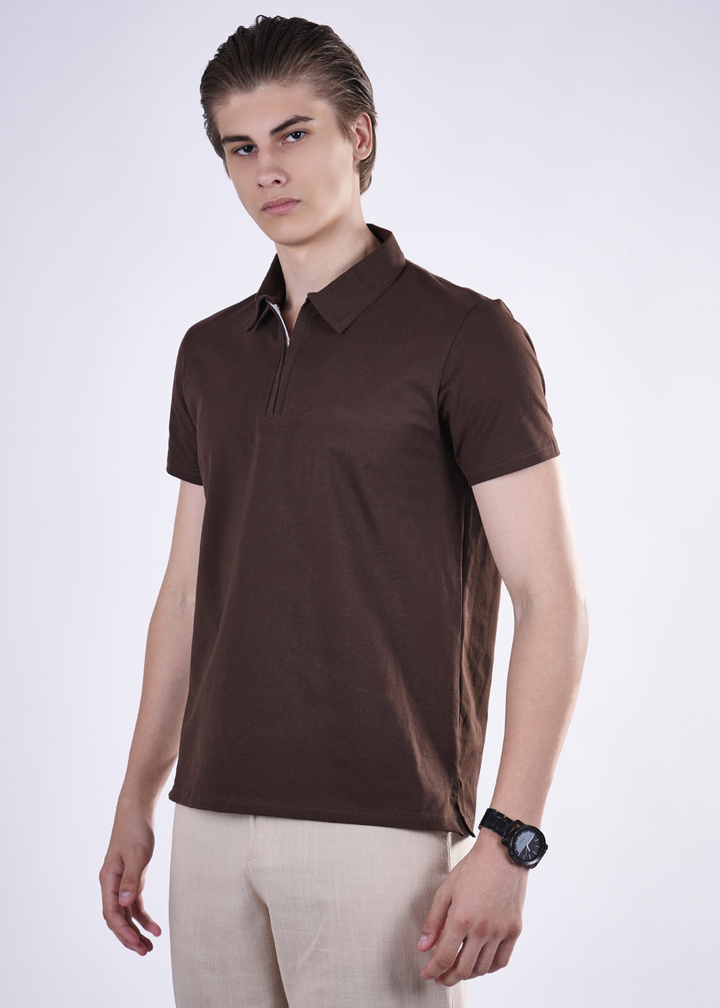 Man wearing a brown polo shirt and beige pants on a white background