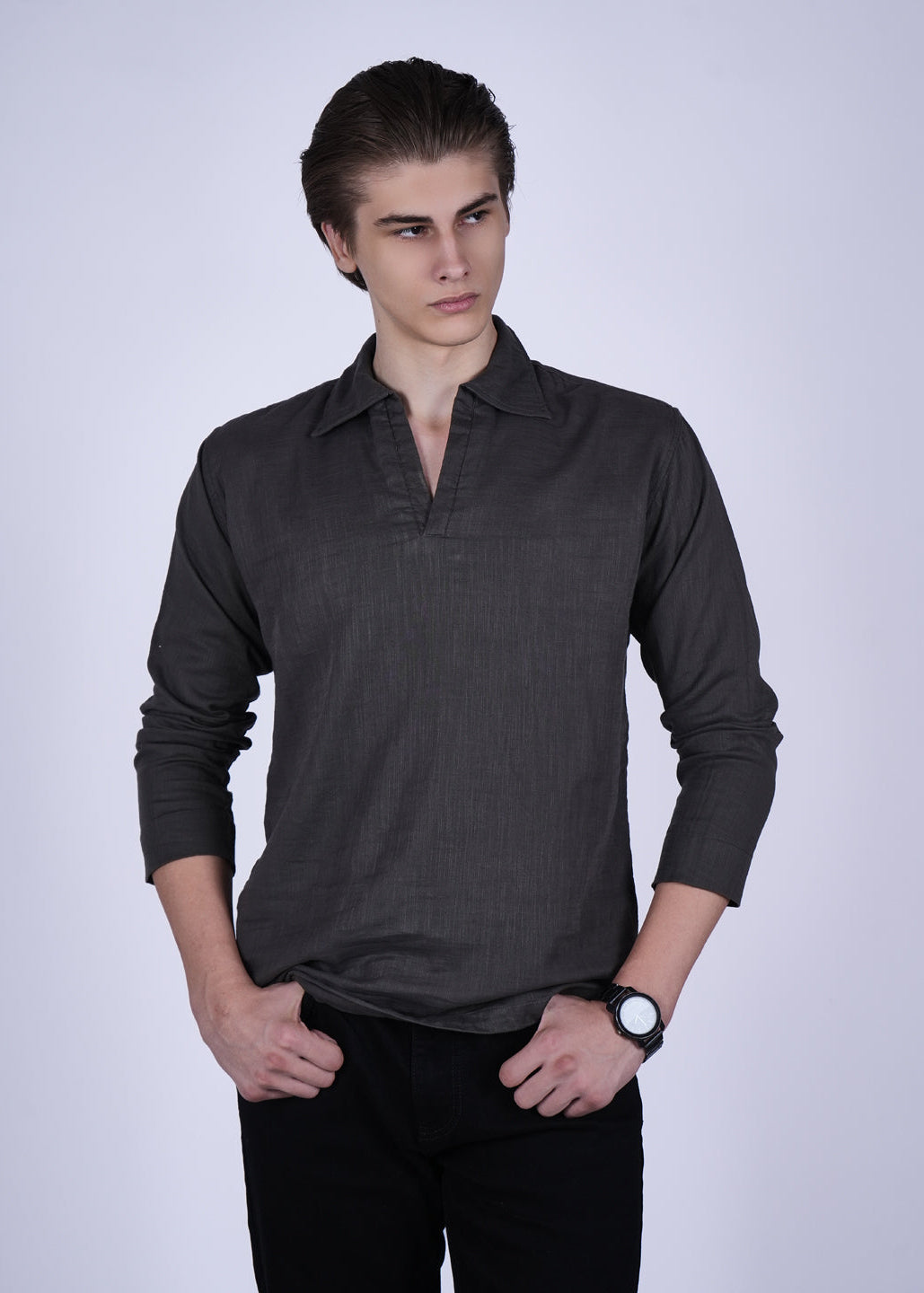 Man wearing a dark gray long-sleeve shirt against a white background