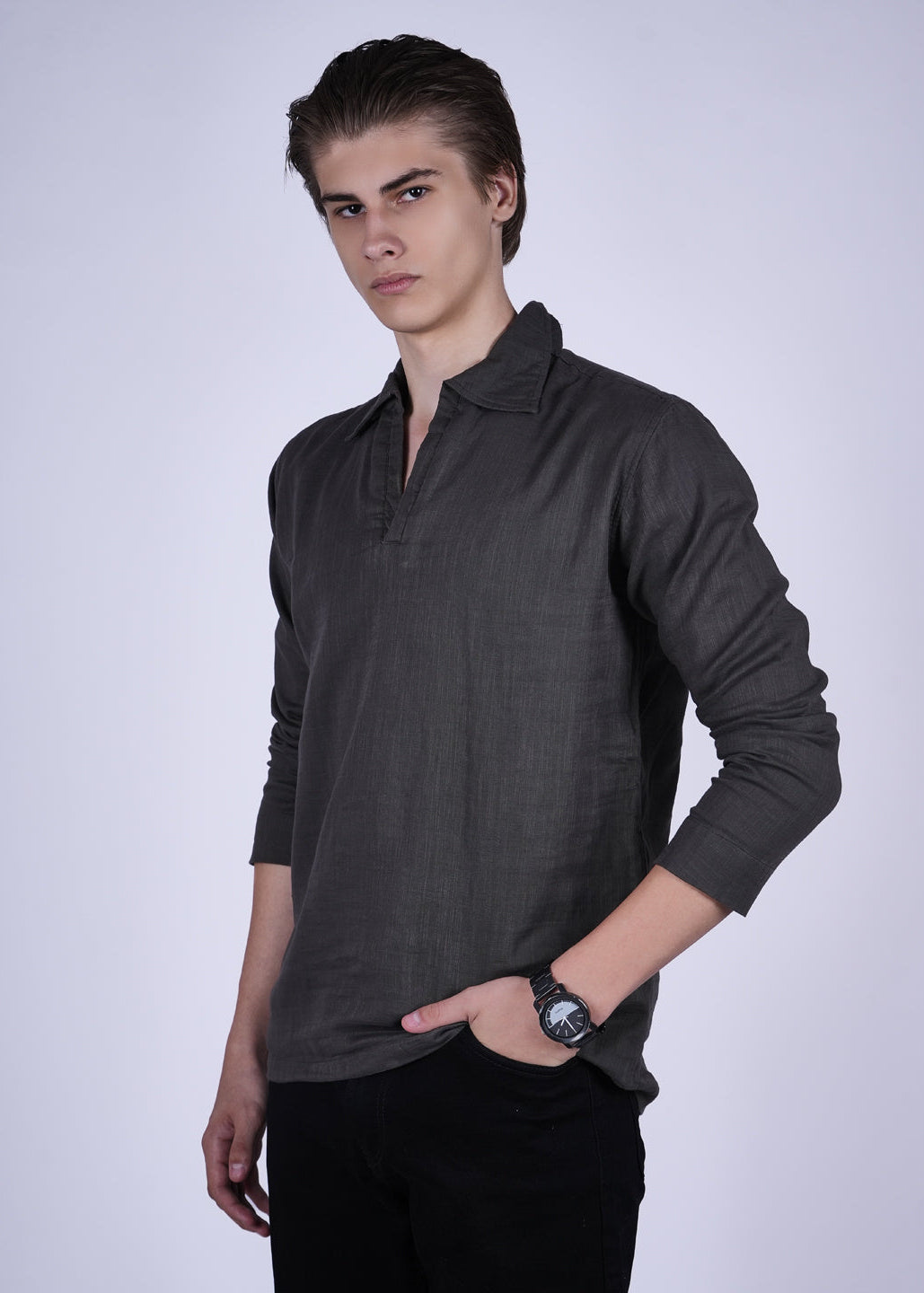 Man wearing a dark gray long-sleeve polo shirt against a white background