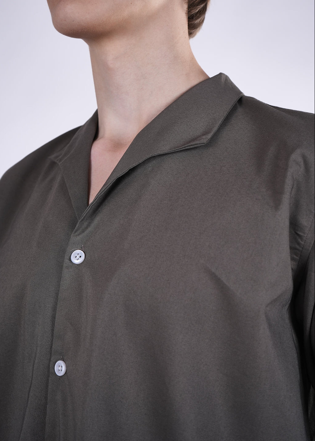 Dark gray shirt with buttons on a plain background