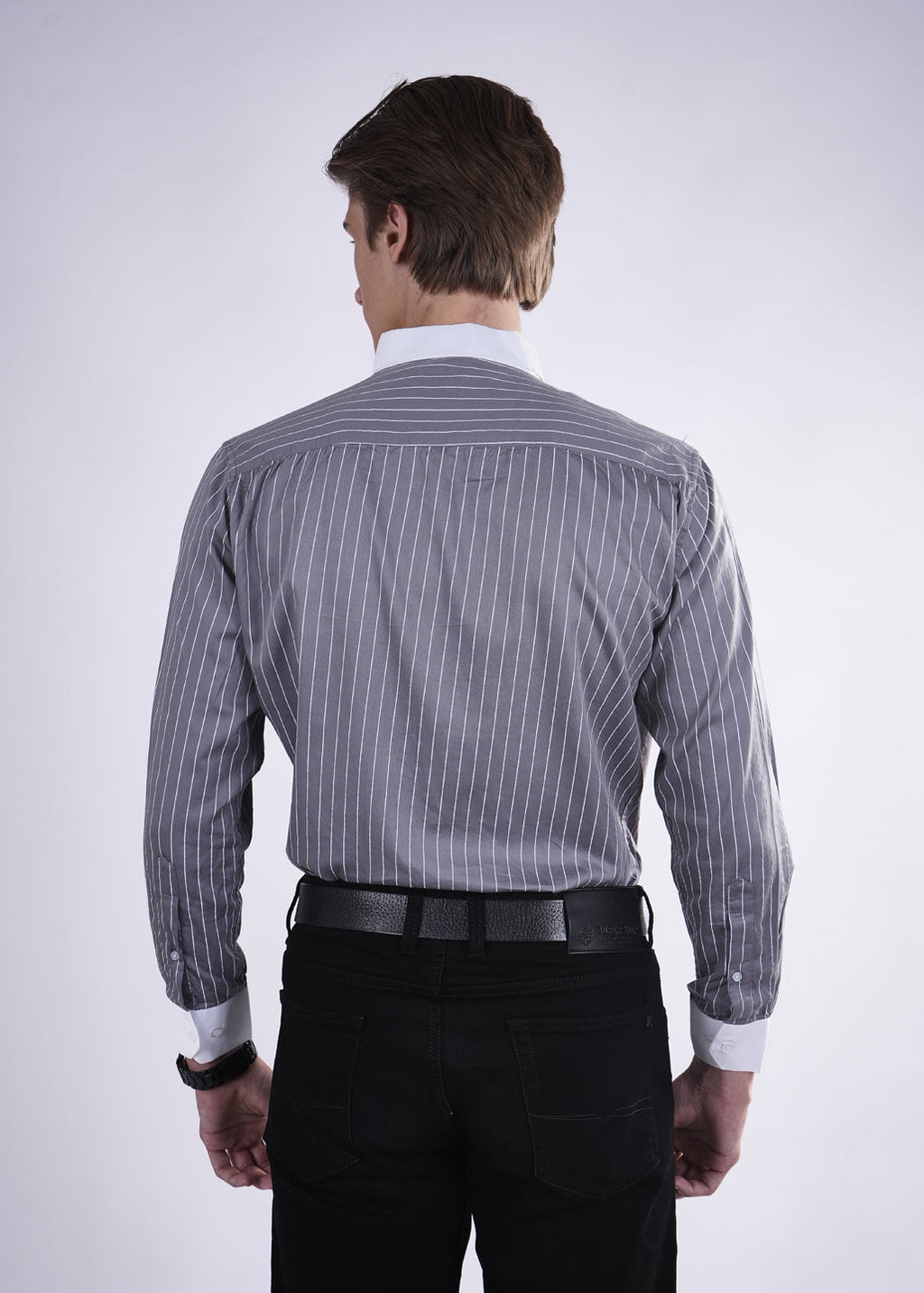 Man wearing a gray striped shirt and black pants on a white background
