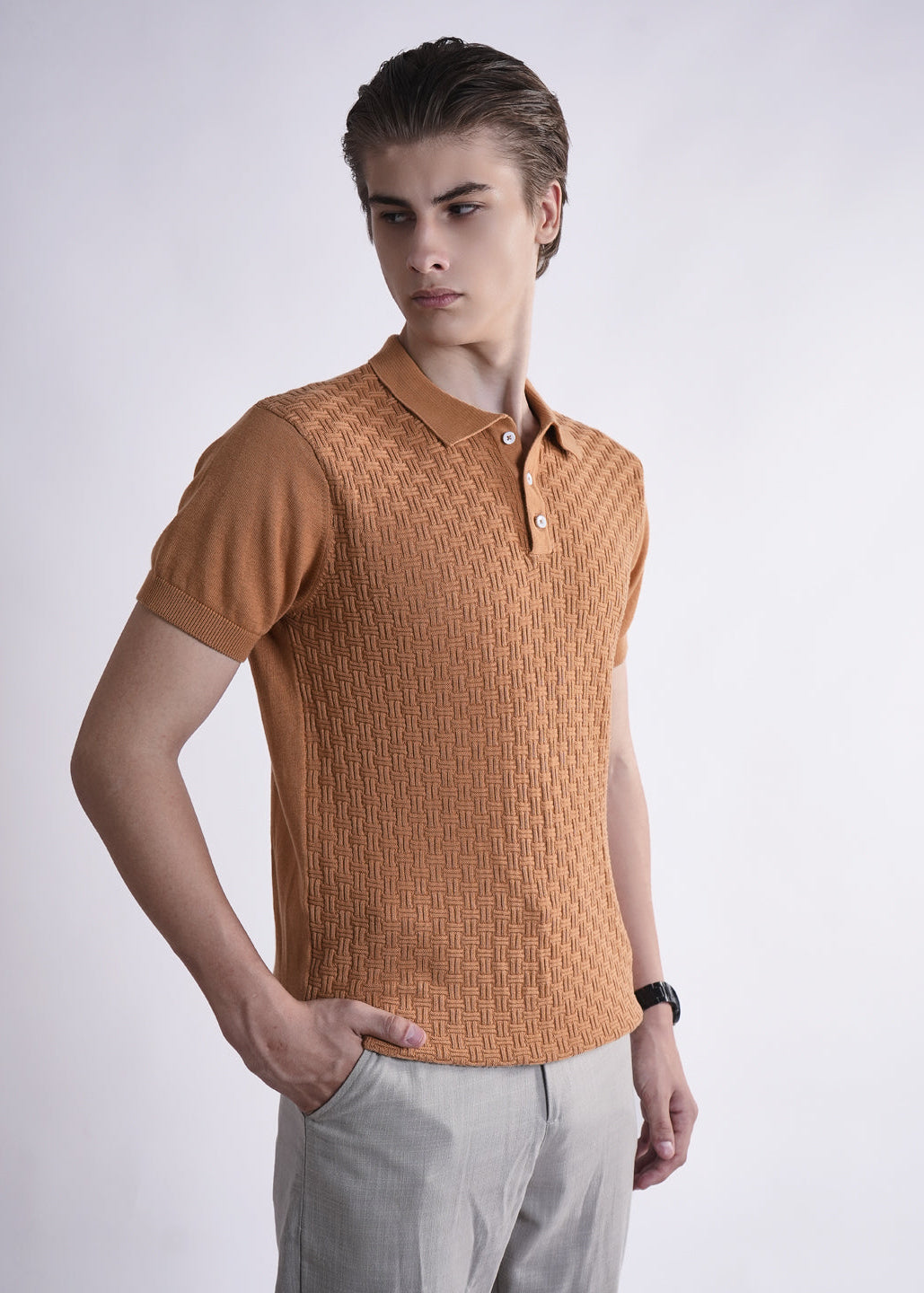 Man wearing a brown textured polo shirt against a white background