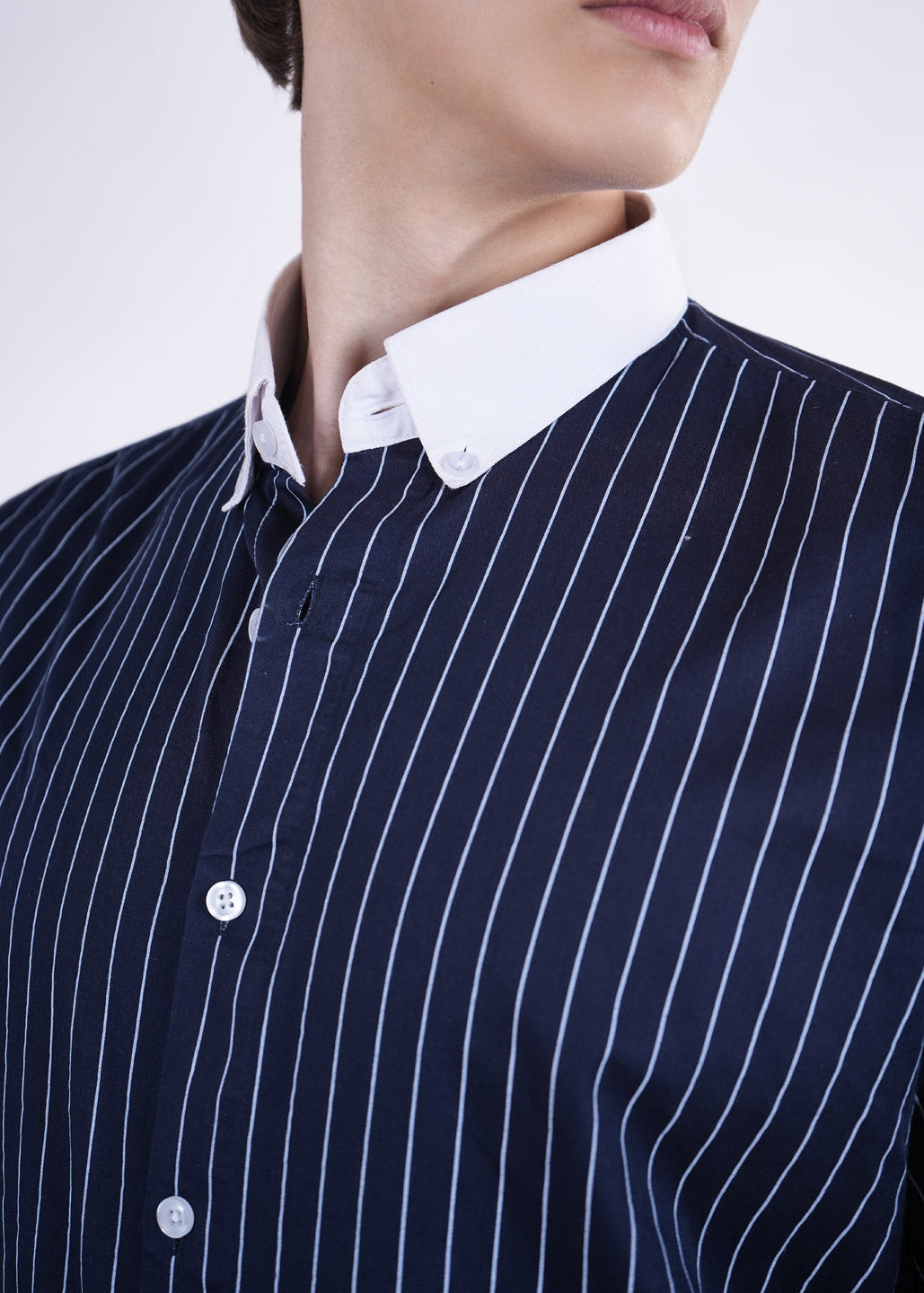 Navy pinstripe shirt with white collar on a plain background