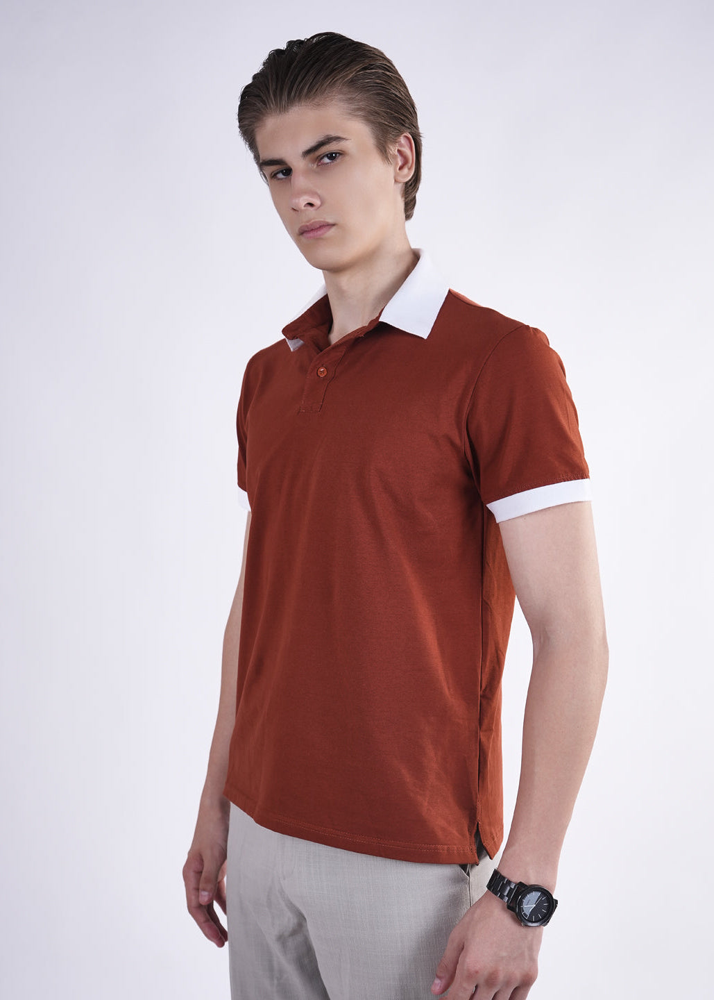Man wearing a brown polo shirt with white collar on a white background