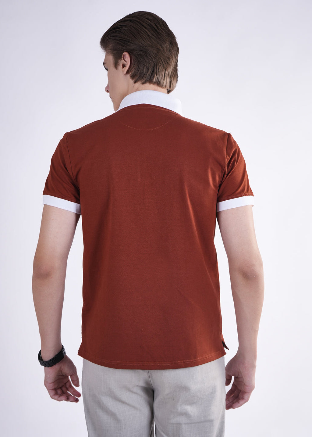 Man wearing a brown polo shirt with white trim on a white background
