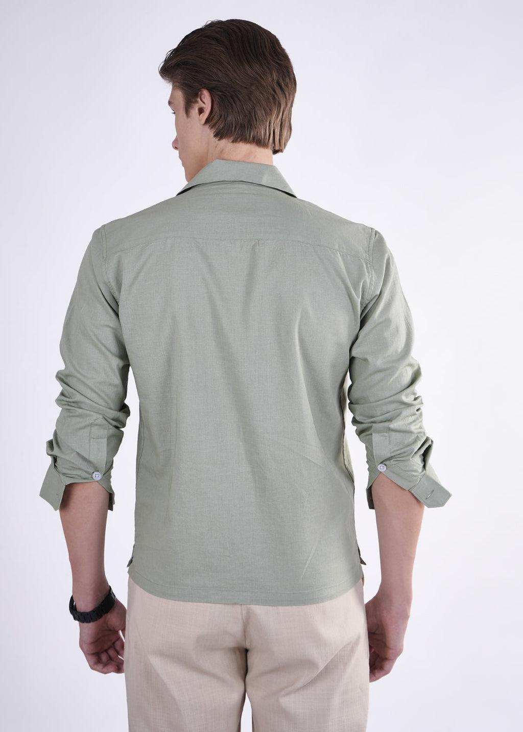 Man wearing a light green shirt and beige pants on a white background