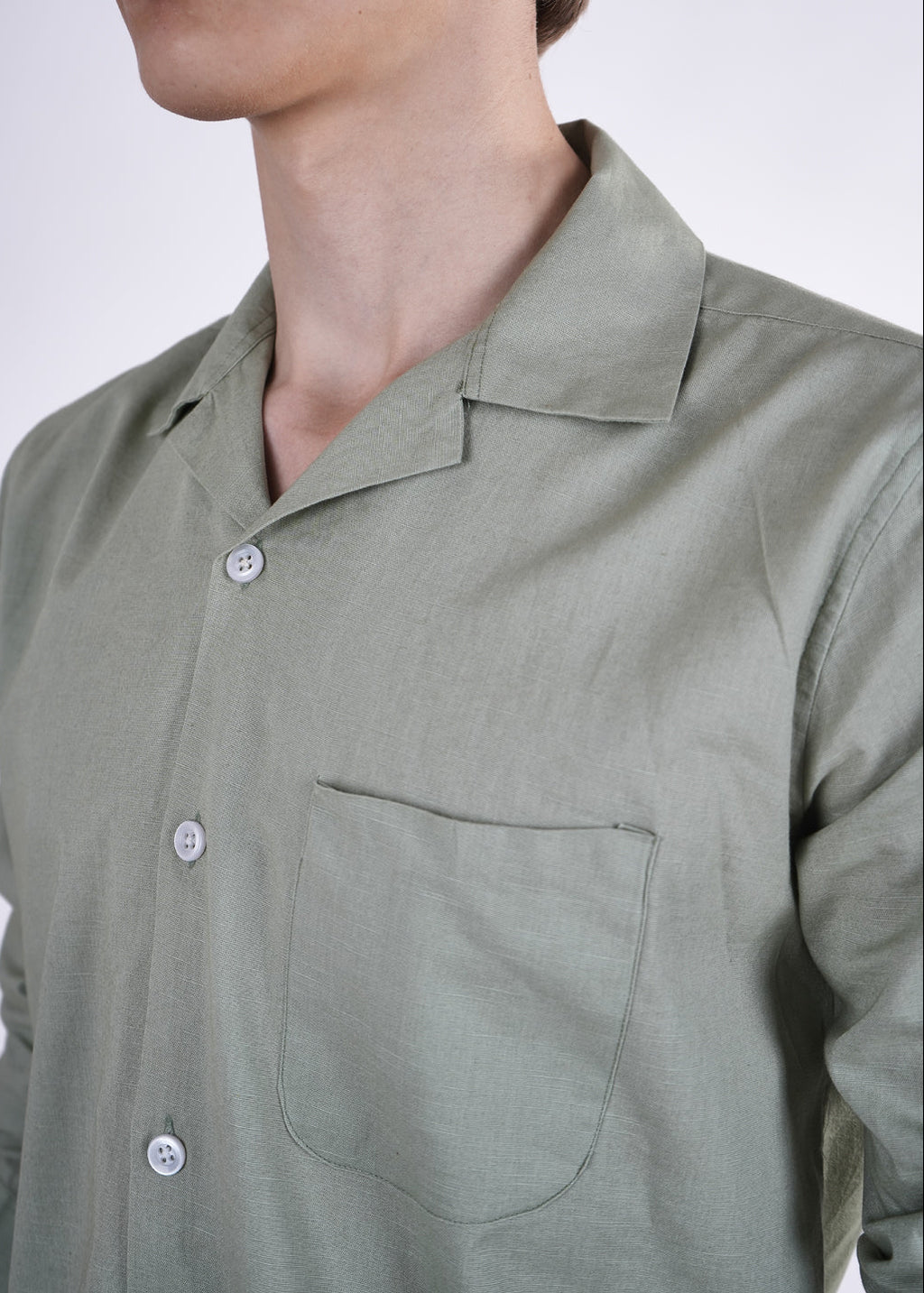Green shirt worn by a person on a white background