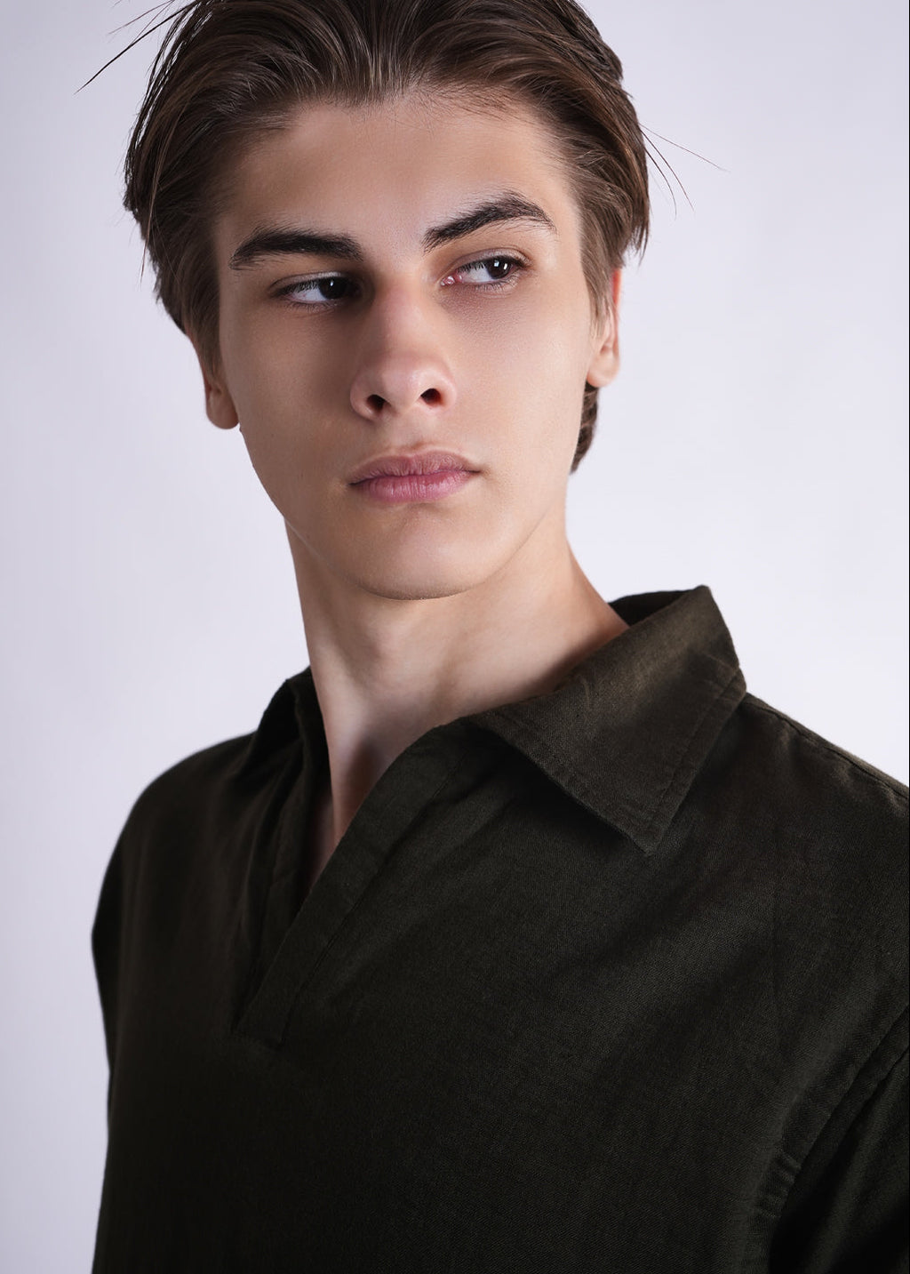 Man wearing a dark brown shirt against a plain background