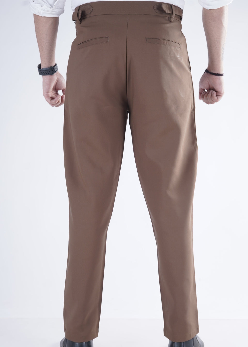 Brown pants worn by a person on a white background