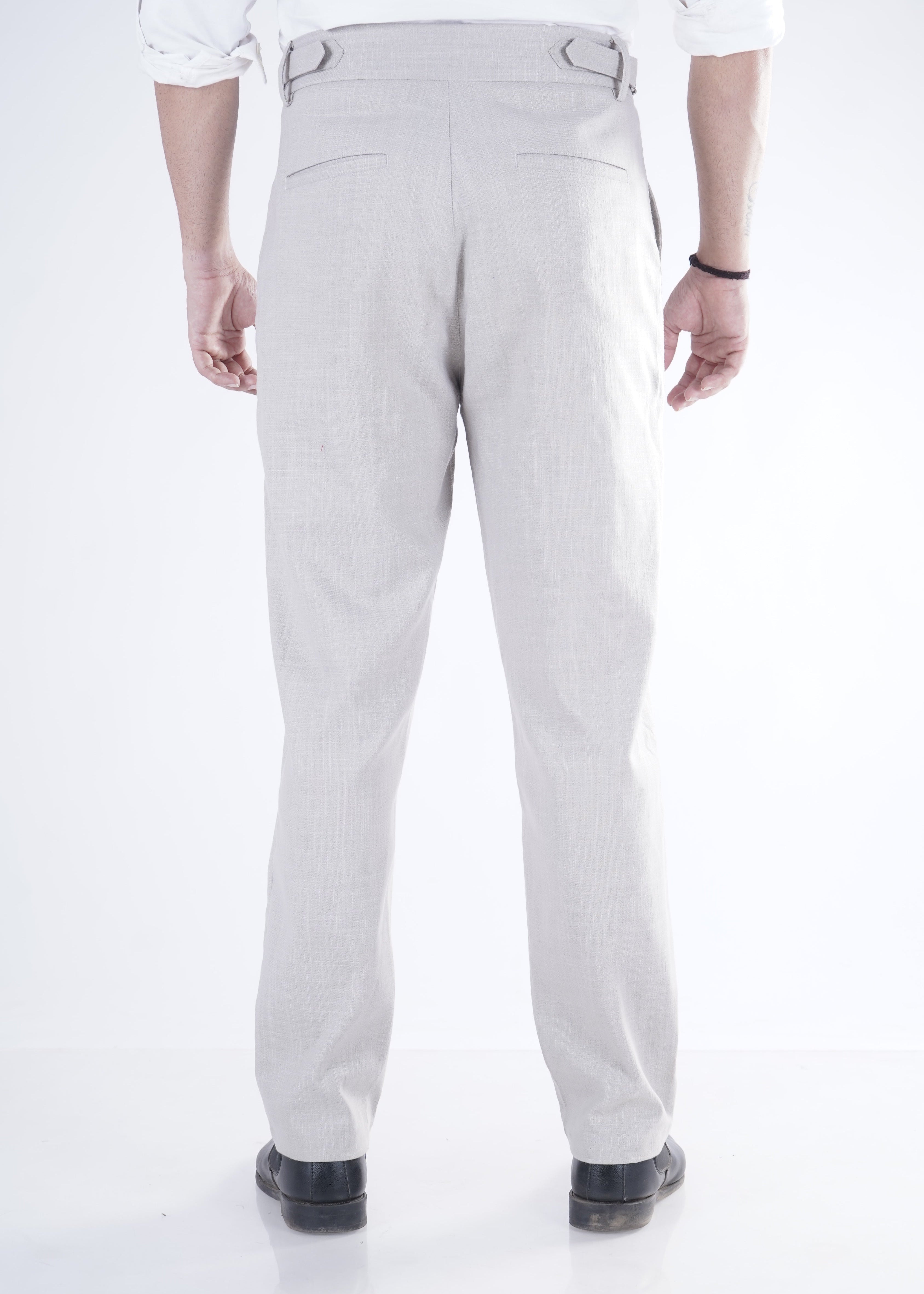 Person wearing light gray pants and a white shirt on a white background
