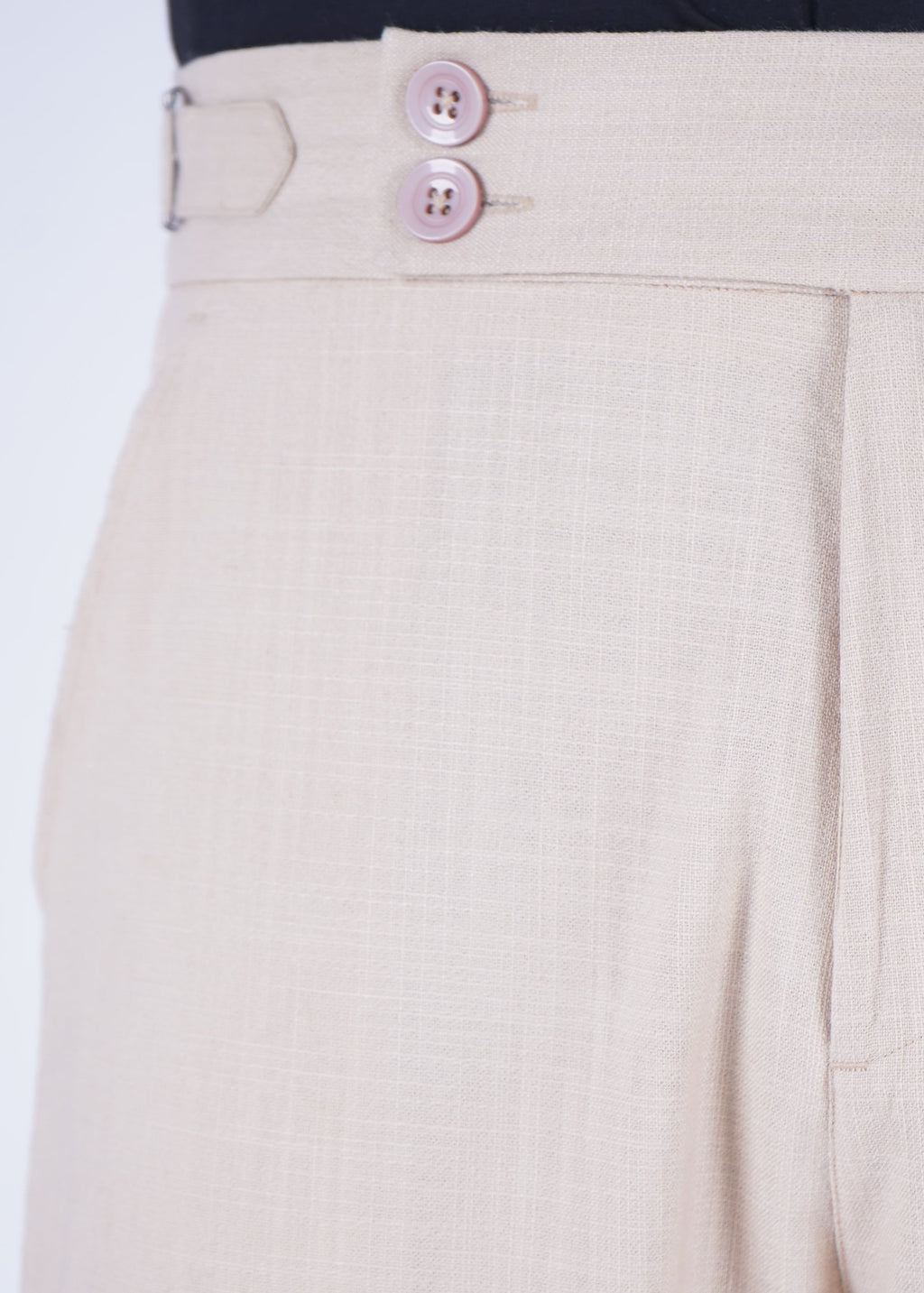 Beige pants with a button detail on a white background